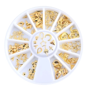 Macro view of gold nail art metal charms stored in a white multi-grid round wheel