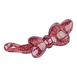 Close-up of a reddish-brown resin banana hair clip with a stylish bow shape and glossy texture