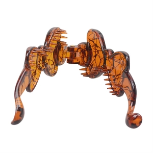 Detailed close-up of tortoise shell resin banana clip featuring smooth amber texture