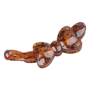 Detail of a brown tortoiseshell bow hair clip made of resin with polished finish