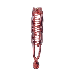 Detail view of a reddish-brown resin banana hair clip with interlocking teeth design