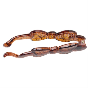 Detail showing tortoise shell pattern on brown resin banana clip with gold hinge