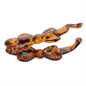 Detail of amber tortoiseshell resin banana hair clip with bow design and inner teeth