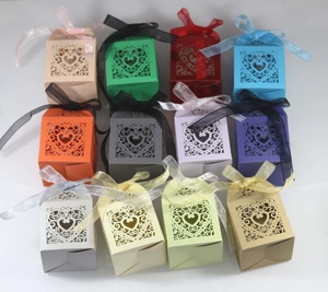 Macro display of twelve colorful laser-cut hollow heart candy gift boxes with silk ribbons