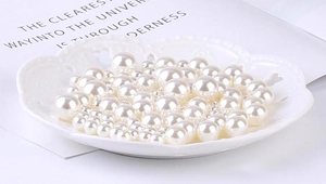 Macro shot of assorted cream white no-hole round pearls for DIY craft and garment decor