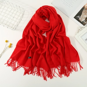 Thick warm red cashmere scarf with fringe tassels and woven brand label for women