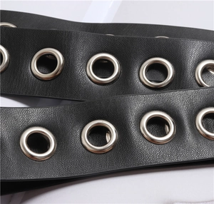 Detailed macro view of black PU leather belt featuring double rows of silver metal eyelets