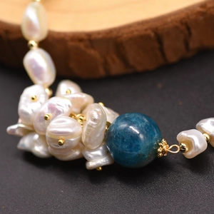 Macro detail of natural baroque pearl and blue kyanite stone with gold metal accents