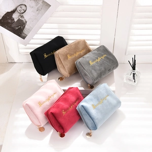 Macro view of six colorful velvet cosmetic bags with gold Beautyforyou embroidery