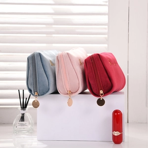 Detailed plush velvet makeup bags in blue, pink, and red with gold 'Beauty' embroidery