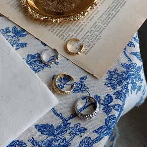 Close-up of irregular textured stackable rings in gold and silver finish on vintage cloth