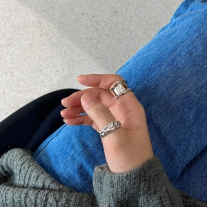 Detail of 925 sterling silver irregular ring set worn with casual denim outfit