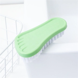 Green foot-shaped scrub brush with white bristles for versatile household cleaning