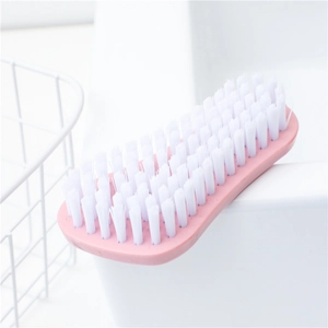 Pink multipurpose hard bristle cleaning brush for shoes and laundry on a washbasin