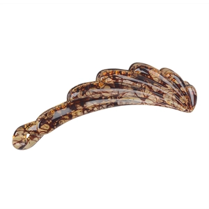 Macro shot of wavy amber resin banana clip with polished finish and twist design detail