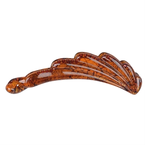 Macro shot of amber resin banana hair clip with textured ridges and glossy finish