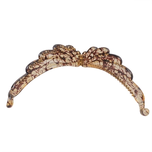 Detail of butterfly-shaped banana hair clip with brown and black tortoiseshell resin pattern