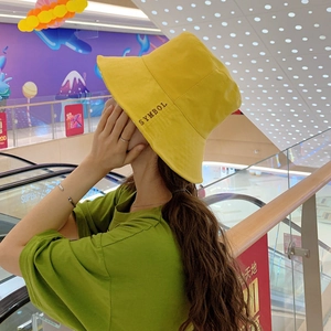 Dettaglio del cappello alla pescatora giallo con ricamo SYMBOL nero preciso sul lato