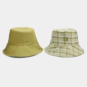 Dettaglio di cappello alla pescatora verde oliva con ricamo e motivo a quadri nel set