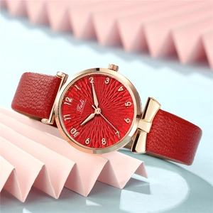 Close-up of a red textured leather strap and rose gold metal casing for women watch