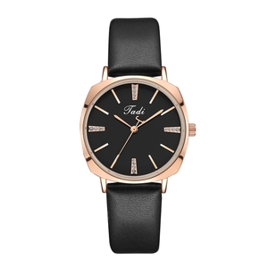 Detail of rose gold watch case with crystal markers and black leather strap