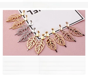 Detailed view of hollow leaf earrings in gold, silver, and rose gold stainless steel