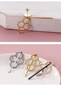 Detailed view of titanium geometric fringe earrings in gold, silver, and rose gold finishes