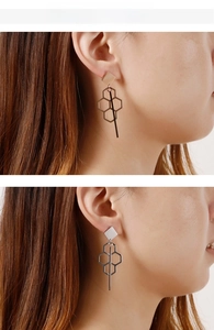 Detailed comparison of gold and silver geometric tassel earrings worn by a model