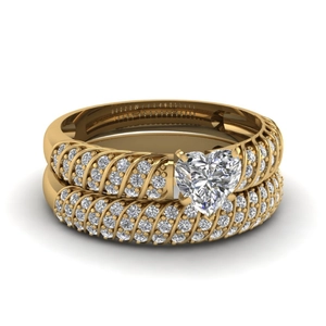 Vue détaillée de la bague spirale dorée avec diamant en forme de cœur et pavé de diamants