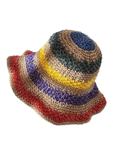 Detailed close-up of handmade multi-color striped crochet straw hat for beach vacations