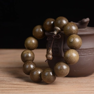 Close-up of 20mm Phoebe wood beads showing fine grain texture and natural oil finish