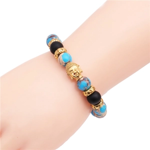 Dettaglio del bracciale con pietre turchesi, perline nere e ciondolo a testa di Buddha