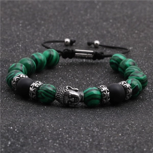 Dettaglio macro del bracciale con perline Buddha in malachite verde e cordino intrecciato