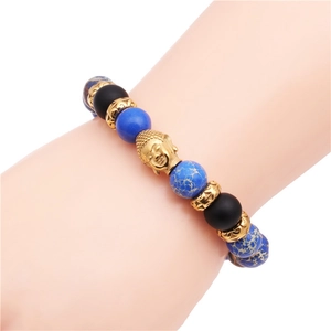 Dettaglio del bracciale intrecciato regolabile con perle blu marmorizzate e testa di Buddha