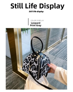 Detail of gray leopard print triangle bag with black handles and gold zipper closure