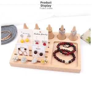Detail of wooden jewelry display featuring cone ring holders and earring slots