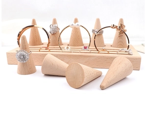 Macro shot of natural beech wood ring display cones and slotted base for jewelry storage