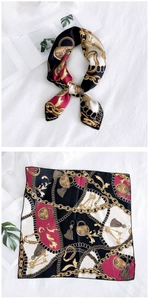 Detail of vintage printed silk scarf with gold chain and padlock patterns on white background