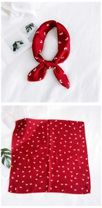 Detail of red square scarf with white leaf pattern showing knotted and flat views