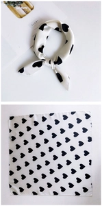 Detail showing creamy silk square scarf with black heart print in a flat and knotted view