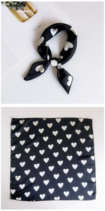Detail of black silk scarf with white heart print showing tied and flat layout