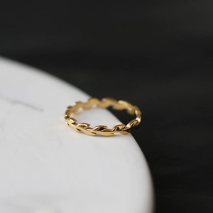 Minimalist 18K gold wheat ear laurel ring on a minimalist white ceramic jewelry plate