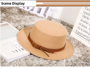 Chic camel flat top wool fedora with buckle strap on a plush grey texture rug