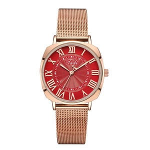 Detail of rose gold mesh strap watch with red dial and roman numeral markers