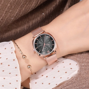 Gros plan d'une montre à quartz or rose avec bracelet en maille et bracelet à billes