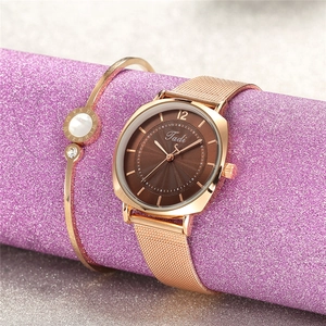 Montre à quartz en or rose avec bracelet en maille et jonc assorti sur support violet