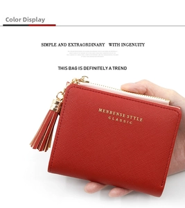Détail d'un portefeuille rouge en similicuir avec zip à pompon doré et design compact