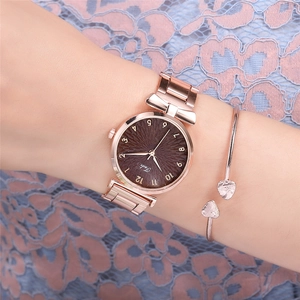 Close-up of a women's rose gold Tadi watch with a brown dial and heart-shaped bracelet