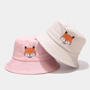 Bobs rose et beige avec broderie renard mignonne présentés sur un fond gris clair
