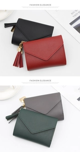 Detail of multi-color envelope wallets with tassels and golden heart pendants